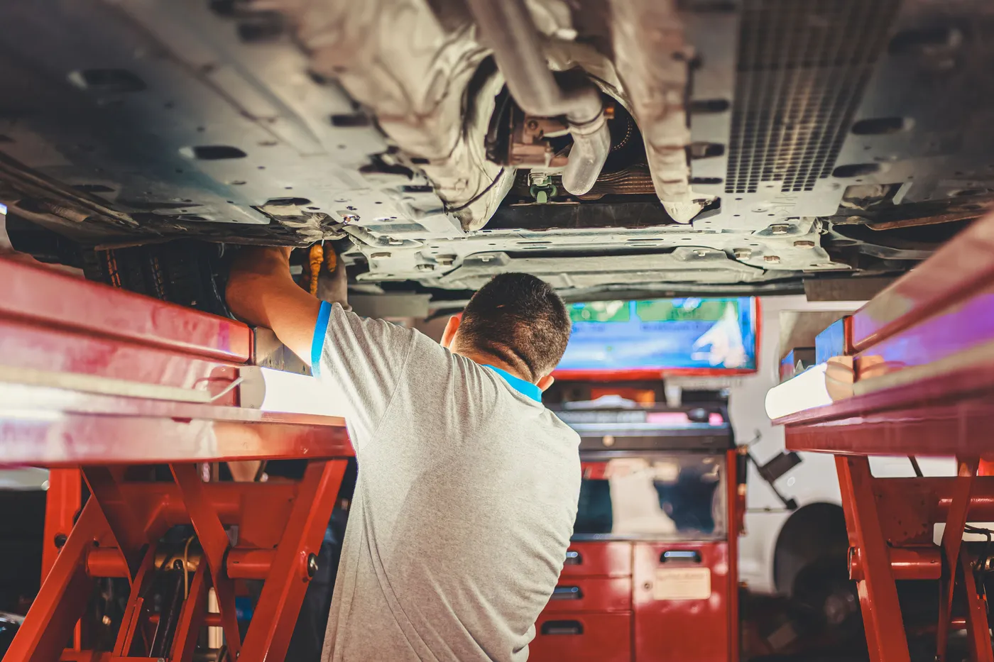 Mechanic working under a car on a hoist