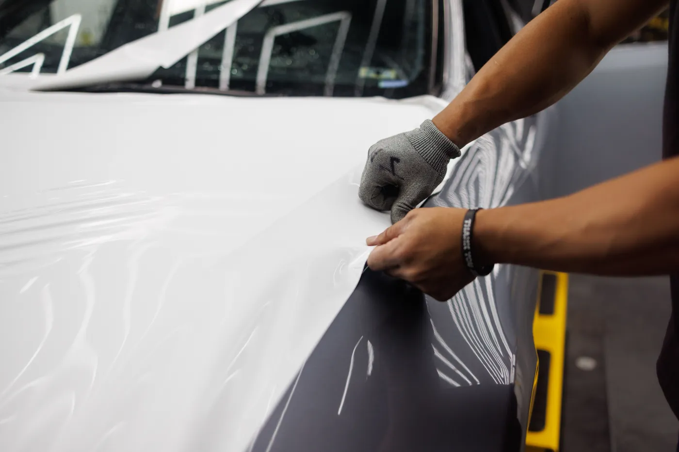 Vinyl wrap being applied to a car panel